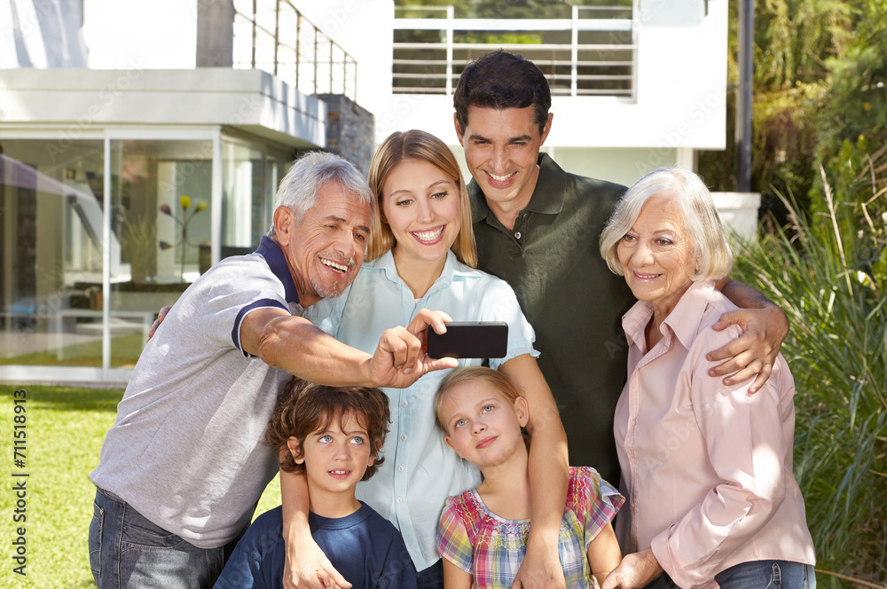 Selfie of family with children and grandparents in summer in garden in front of house