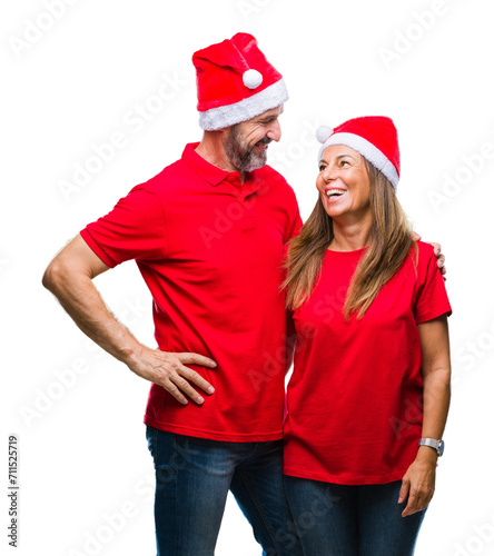 Middle age hispanic couple wearing christmas hat over isolated background with a happy and cool smile on face. Lucky person.