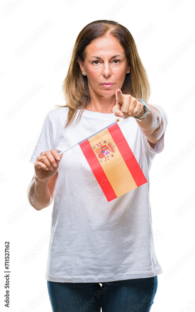 Middle age hispanic woman holding flag of Spain over isolated background pointing with finger to the camera and to you, hand sign, positive and confident gesture from the front Middle age hispanic woman holding flag of Spain over isolated background pointing with finger to the camera and to you, hand sign, positive and confident gesture from the front