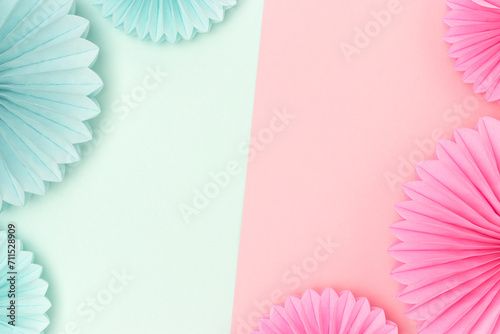 Border frame made of tissue paper fans in a pink and blue colors. Gender reveal party concept with copy space.