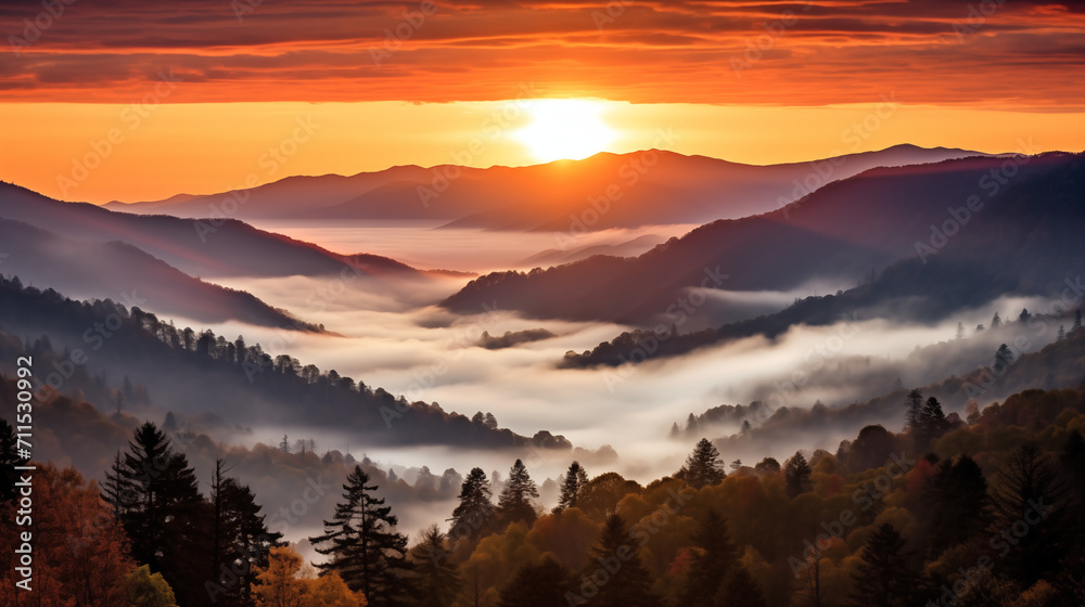 a smoky mountain sunset, where the sky is ablaze with warm tones as the sun bids farewell behind the peaks. The mountains are veiled in a delicate mist - obrazy, fototapety, plakaty 