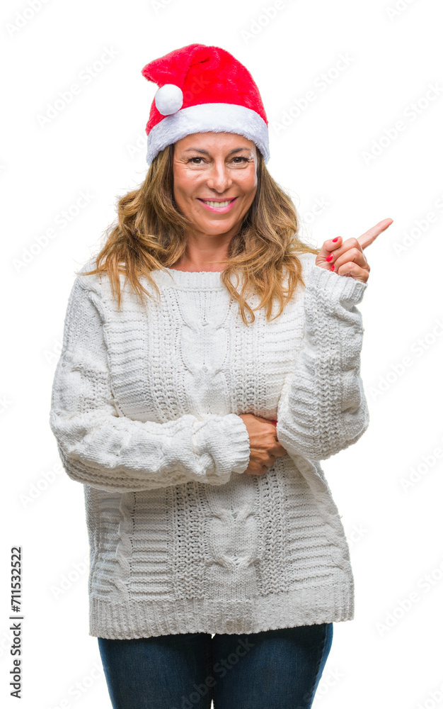 Middle age senior hispanic woman wearing christmas hat over isolated background with a big smile on face, pointing with hand and finger to the side looking at the camera. Middle age senior hispanic woman wearing christmas hat over isolated background with a big smile on face, pointing with hand and finger to the side looking at the camera.