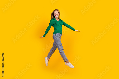 Full body size photo of jumping carefree young girl teenager running into bright future happiness isolated on yellow color background