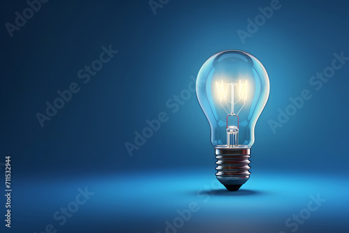 Electric burning light bulb on a plain blue background. photo