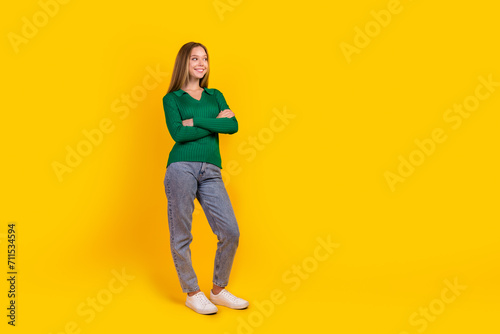 Full body photo of positive blonde hair teenager girl crossed arms looking empty space ideas brainstorm isolated on yellow color background