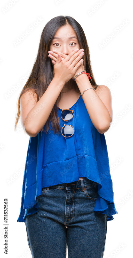 Young asian woman over isolated background shocked covering mouth with hands for mistake. Secret concept.