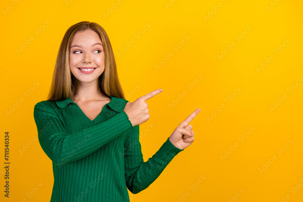 Portrait of lovely positive person beaming smile look indicate fingers empty space offer isolated on yellow color background Portrait of lovely positive person beaming smile look indicate fingers empty space offer isolated on yellow color background