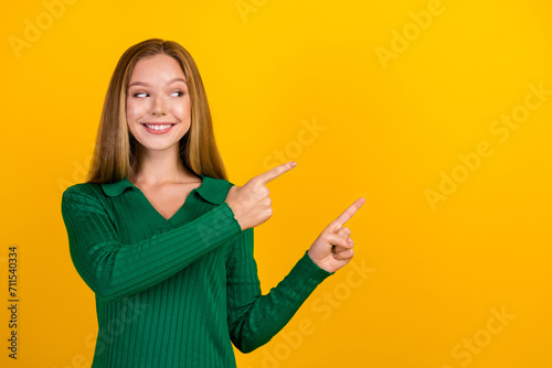Portrait of lovely positive person beaming smile look indicate fingers empty space offer isolated on yellow color background