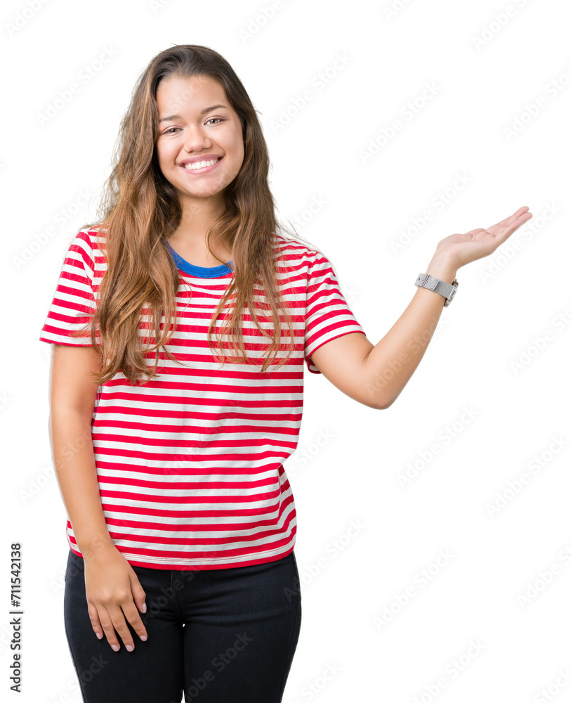 Young beautiful brunette woman wearing stripes t-shirt over isolated background smiling cheerful presenting and pointing with palm of hand looking at the camera. Young beautiful brunette woman wearing stripes t-shirt over isolated background smiling cheerful presenting and pointing with palm of hand looking at the camera.