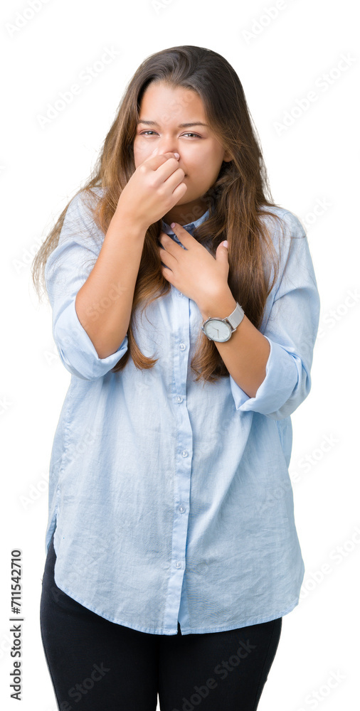 Young beautiful brunette business woman over isolated background smelling something stinky and disgusting, intolerable smell, holding breath with fingers on nose. Bad smells concept. Young beautiful brunette business woman over isolated background smelling something stinky and disgusting, intolerable smell, holding breath with fingers on nose. Bad smells concept.