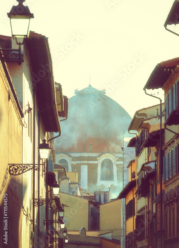 Partial view of Brunelleschi's Dome in Florence. Unusual view in a glimpse of an alley. Photo taken in winter. photo