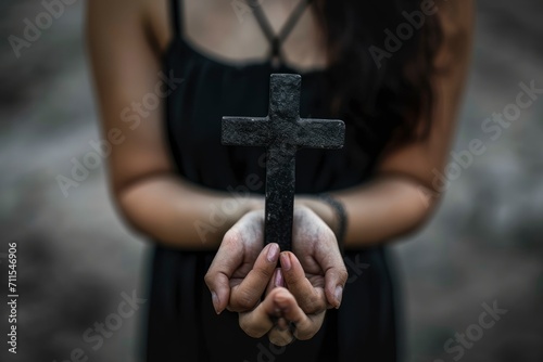 Woman praying with a Catholic cross in her hands, praying for salvation to Jesus Christ, jewelry in the form of crosses on her hands and body