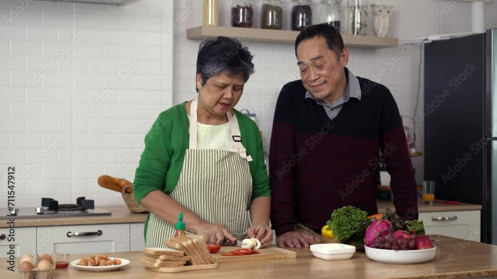 Attractive mature couple cooking foods for breakfast in kitchen with happiness Attractive mature couple cooking foods for breakfast in kitchen with happiness