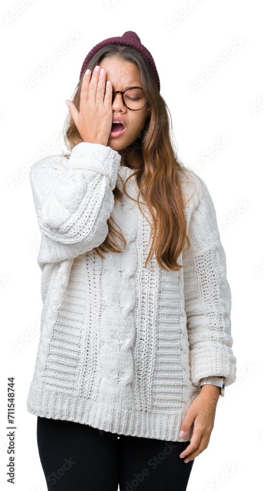 Young beautiful brunette hipster woman wearing glasses and winter hat over isolated background Yawning tired covering half face, eye and mouth with hand. Face hurts in pain. Young beautiful brunette hipster woman wearing glasses and winter hat over isolated background Yawning tired covering half face, eye and mouth with hand. Face hurts in pain.