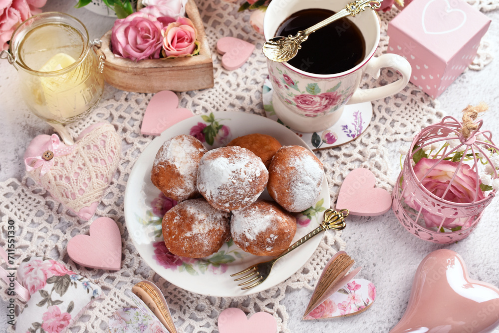 Mini donuts sprinkled with powdered sugar and cup of coffee for Valentine party