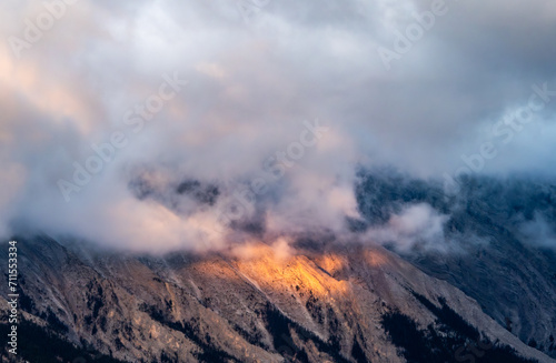 Sunrise light under clouds in the mountain peak