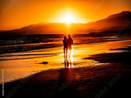 Fototapeta Naklejka Na Ścianę i Meble -  couple walking on the beach at sunset