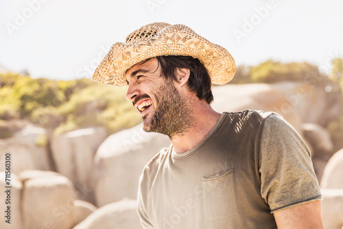 Man in cowboy hat at the beach laughing off camera. Cape Town, South Africa photo