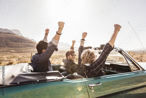 Group of friends driving around and having fun in the South African countryside in a vintage convertible. Paarl, South Africa photo