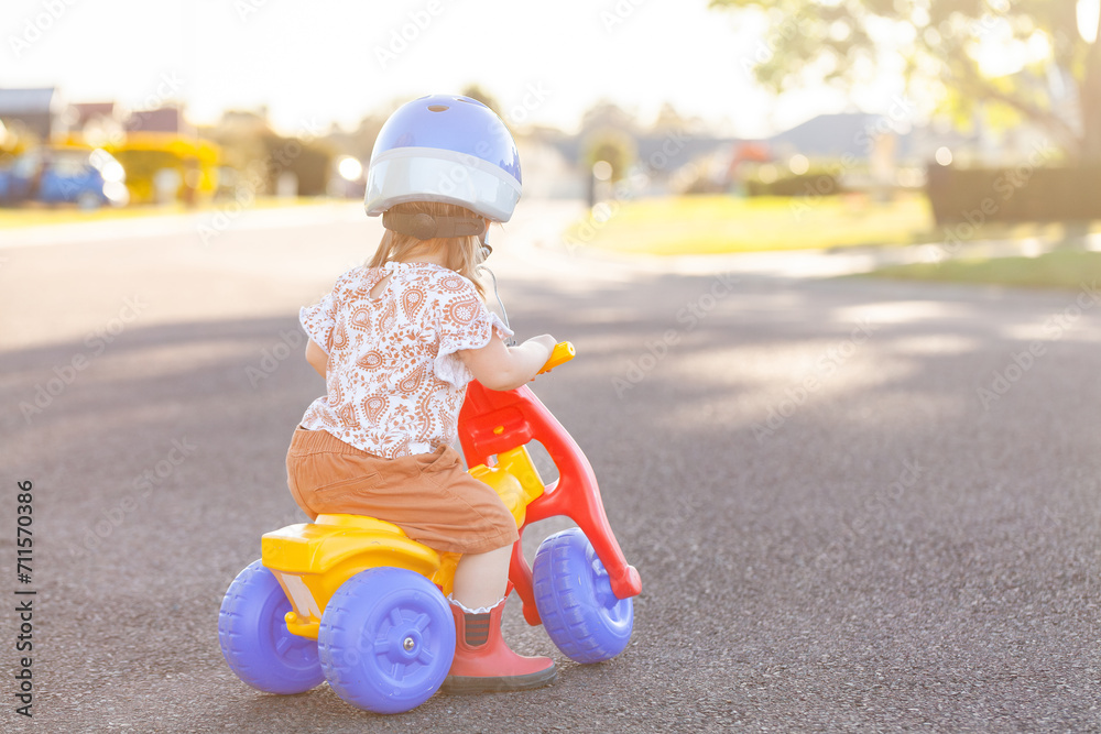 Aussie kid riding tricycle outside on quiet suburban road Aussie kid riding tricycle outside on quiet suburban road