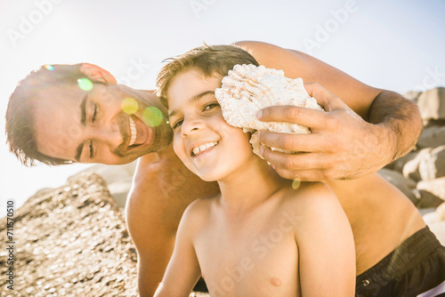 Mixed race father and son having fun playing on the beach. Cape Town, South Africa photo