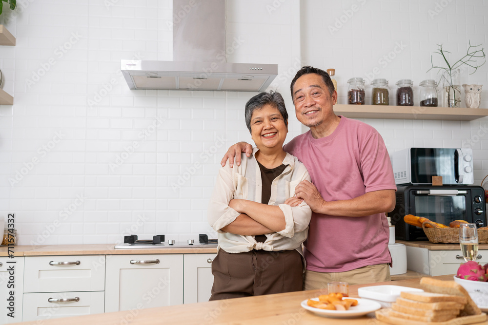 Cheerful Mature couple have spending time together in kitchen Cheerful Mature couple have spending time together in kitchen