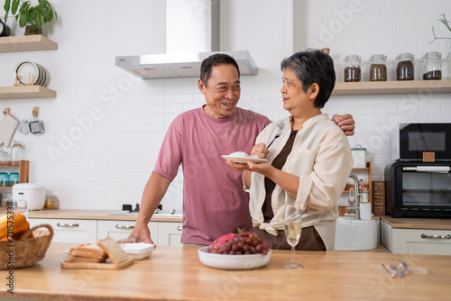 Cheerful Mature couple have spending time with fruit together in kitchen