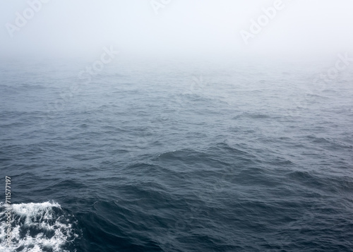 Russia Sakhalin Oblast 27.07.2023 Sea of Okhotsk in the fog. The line of the horizon, dissolving in the fog. The ship's footprint on the water. Space for text. Marine texture © Marina
