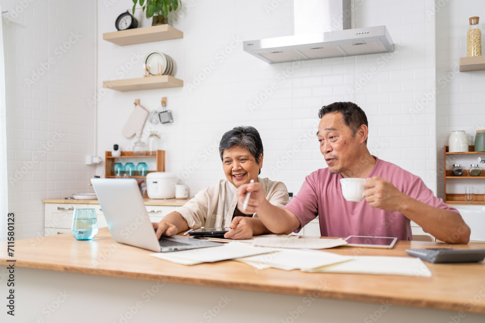 Happy Asian senior couple use digital technology device to working at home Happy Asian senior couple use digital technology device to working at home
