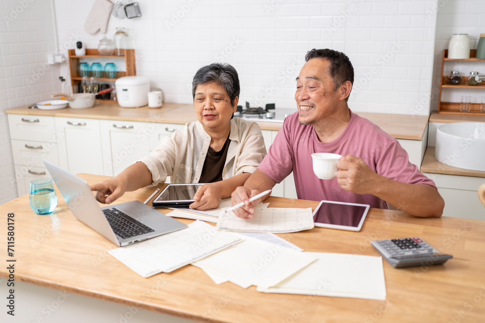 Happy Asian senior couple use digital technology device to working at home Happy Asian senior couple use digital technology device to working at home