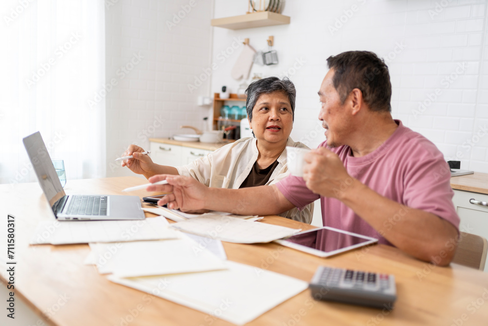Happy Asian senior couple use digital technology device to working at home Happy Asian senior couple use digital technology device to working at home