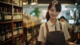Asian female employee working with confidence against the background of liquor shelves in a department store.