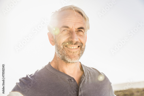 best ager Mann bei Sonnenuntergang am Steg und Meer, Kapstadt, Südafrika photo