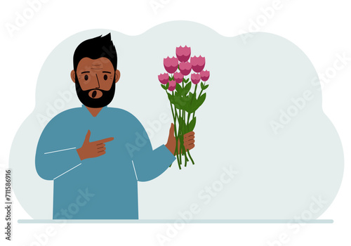 A man is holding a large bouquet of flowers. The concept of a holiday, congratulations, romance or gift.