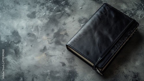 Elegant black leather journal on a moody grey textured background