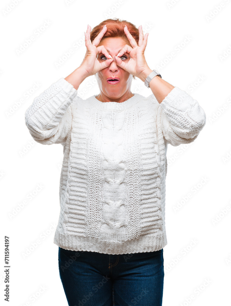 Atrractive senior caucasian redhead woman wearing winter sweater over isolated background doing ok gesture like binoculars sticking tongue out, eyes looking through fingers. Crazy expression. Atrractive senior caucasian redhead woman wearing winter sweater over isolated background doing ok gesture like binoculars sticking tongue out, eyes looking through fingers. Crazy expression.