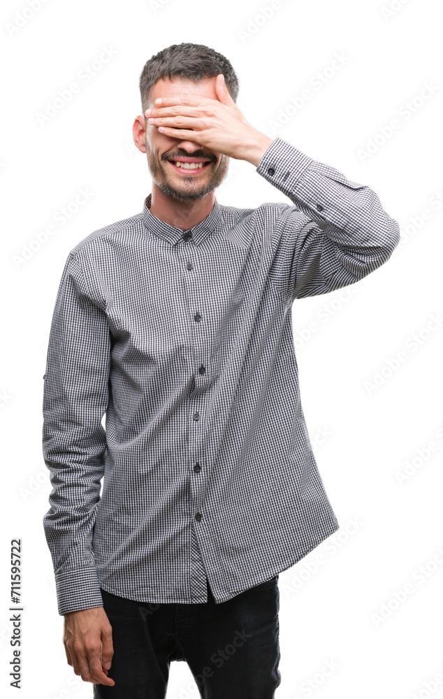 Young hipster man smiling and laughing with hand on face covering eyes for surprise. Blind concept. Young hipster man smiling and laughing with hand on face covering eyes for surprise. Blind concept.