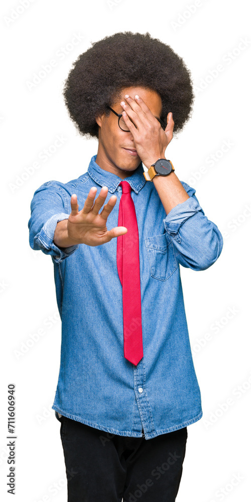Young african american business man with afro hair wearing glasses and red tie covering eyes with hands and doing stop gesture with sad and fear expression. Embarrassed and negative concept. Young african american business man with afro hair wearing glasses and red tie covering eyes with hands and doing stop gesture with sad and fear expression. Embarrassed and negative concept.