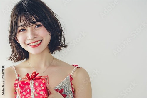 プレゼントを手に持つ日本人女性（クリスマス・バレンタイン・記念日・背景なし）