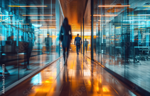 Motion blur business people in an office with glass partitions