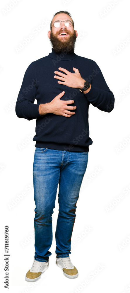 Fototapeta premium Young blond man wearing glasses and turtleneck sweater Smiling and laughing hard out loud because funny crazy joke. Happy expression.