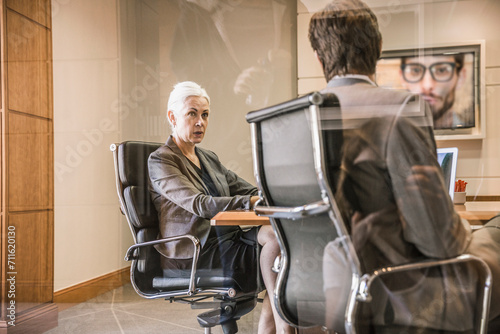 Two colleagues having a teams meeting in a conference room with third colleague