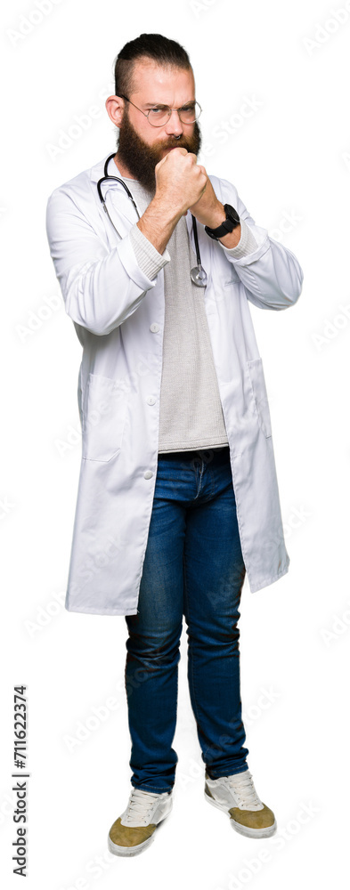 Young blond doctor man with beard wearing medical coat Ready to fight with fist defense gesture, angry and upset face, afraid of problem Young blond doctor man with beard wearing medical coat Ready to fight with fist defense gesture, angry and upset face, afraid of problem