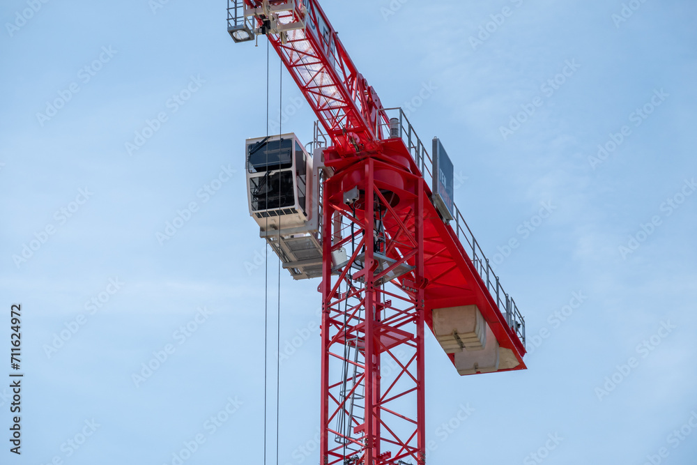 Detail of red tower crane with telescopic arm, stairs and cabin for workers, Netherlands Detail of red tower crane with telescopic arm, stairs and cabin for workers, Netherlands