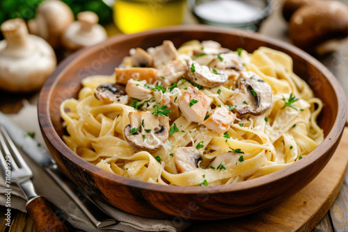 Tagliatelle with mushrooms and cream sauce in a wooden bowl