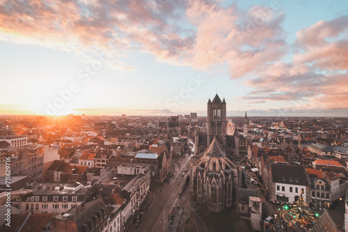 Watching the sunset over Ghent from the historic tower in the city centre. Romantic colours in the sky. Red light illuminating Ghent, Flanders region, Belgium © Fauren