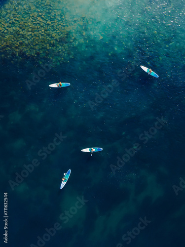 Group of people on stand up paddle board at sea. People on Sup board in Mediterranean sea. Aerial view © artifirsov