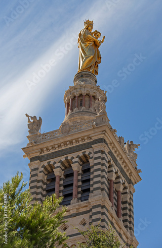 Golden blessed Mary with Jesus child on top of the tower of Cathedral of Notre-Dame de la Garde in Marseille, France