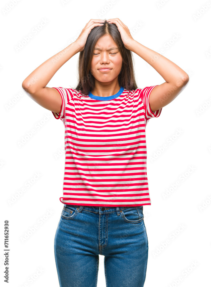 Young asian woman over isolated background suffering from headache desperate and stressed because pain and migraine. Hands on head. Young asian woman over isolated background suffering from headache desperate and stressed because pain and migraine. Hands on head.