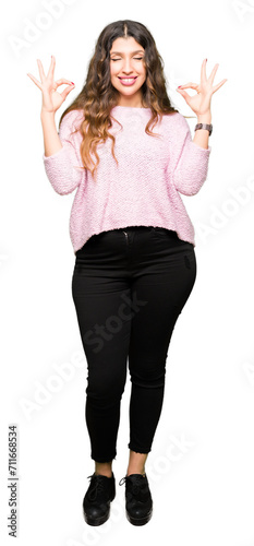 Young beautiful woman wearing pink sweater relax and smiling with eyes closed doing meditation gesture with fingers. Yoga concept.
